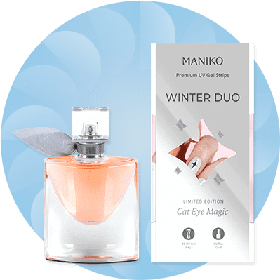 Eine Parfümflasche mit orangefarbenem Inhalt neben einer Verpackung mit der Aufschrift „MANIKO Winter Duo, Limited Edition, Cat Eye Magic“