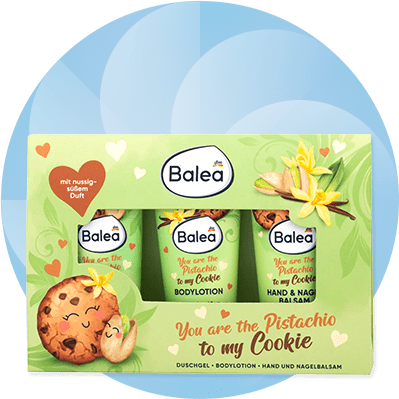 Eine grüne Verpackung mit drei Balea-Produkten, Aufschrift „You are the Pistachio to my Cookie“, mit Herz- und Keksdesign, Duft „nussig-süß“