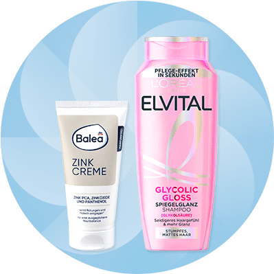Eine Tube Balea Zink Creme neben einer Flasche L'Oréal Elvital Glycolic Gloss Shampoo auf blauem Hintergrund