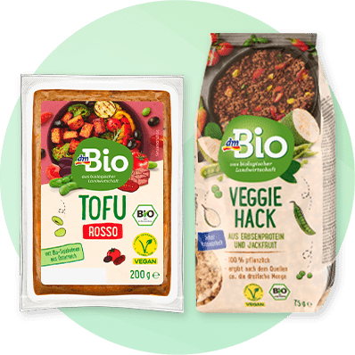 Zwei Produktverpackungen von dmBio: links Tofu Rosso mit Gemüseabbildung, rechts Veggie Hack aus Erbsenprotein und Jackfrucht mit grünen Erbsen und Hackabbildung