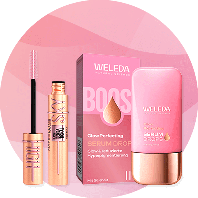 Eine rosa Verpackung von Weleda Glow Perfecting Serum Drops neben einem geöffneten Mascara mit rosa Bürste.