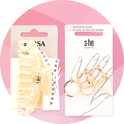 Eine Haarspange mit Blumenmuster und ein Set goldener Ohrringe auf Verpackungen mit den Aufschriften „Rosa“ und „she“