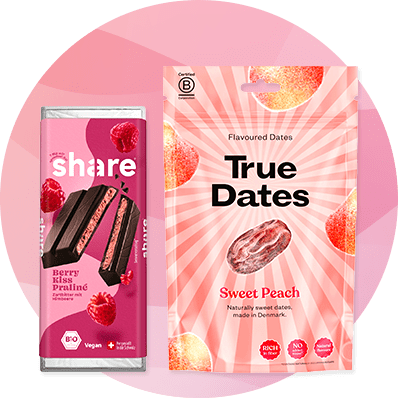 Eine rosa Verpackung von „Share“ mit Himbeeren und eine Packung „True Dates“ mit der Aufschrift „Sweet Peach“ auf gestreiftem Hintergrund.