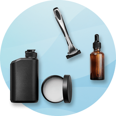 Eine schwarze Shampoo-Flasche, ein Rasierer, ein offener Cremetiegel und eine braune Glasflasche mit Pipette auf blauem Hintergrund