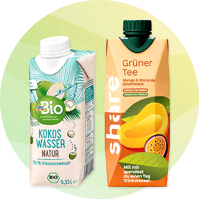 Zwei Getränkepackungen vor hellem Kreis: links eine weiße dmBio Kokoswasser-Packung mit grünen Akzenten und Aufschrift „Kokos Wasser Natur 100% Kokosnusswasser 0,33 l“, rechts eine orange-grüne Shäre-TetraPak mit Aufschrift „Grüner Tee Mango & Maracuja Geschmack“ und Hinweis „Mit mir spendest du einen Tag Trinkwasser“