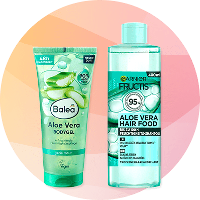Links eine grüne Balea Aloe Vera Bodygel-Tube mit Aufschrift „Aloe Vera Bodygel“ und Symbol „Vegan“, rechts eine transparente Garnier Fructis Aloe Vera Hair Food Flasche mit Aufschrift „95%“ und „Aloe Vera Hair Food“