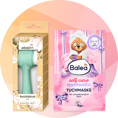 links eine mintgrüne Gesichtsbürste der Marke ebelin in türkis-weißem Gehäuse in braunem Karton mit Blumenmuster, rechts eine rosa Balea Tuchmaske-Verpackung mit Zeichnung eines Bären mit Handtuchturban, Aufschrift „self care moments TUCHMASKE“