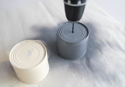 Mit dem Bohrer ein Loch in der Dose machen