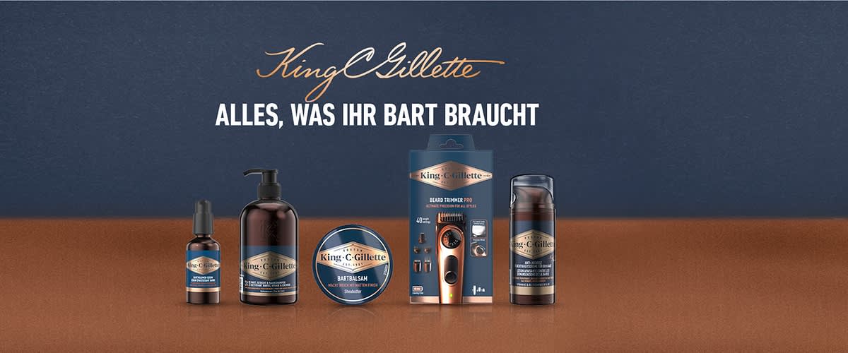 Produktaufstellung von King C. Gillette Bartpflegeprodukten mit Schriftzug „King C. Gillette“ oben und Slogan „ALLES, WAS IHR BART BRAUCHT“ darunter, fünf Produkte in einer Reihe (Öl, Pumpflasche, Bartbalsam Dose, elektrischer Trimmer in Verpackung, Sprühflasche)