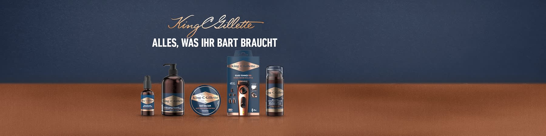 King C. Gillette Bartpflege-Serie mit Bartöl, Pump-Flasche, Bartbalsam, Barttrimmer in Verpackung und Rasierschaum nebeneinander, Slogan „Alles, was Ihr Bart braucht“