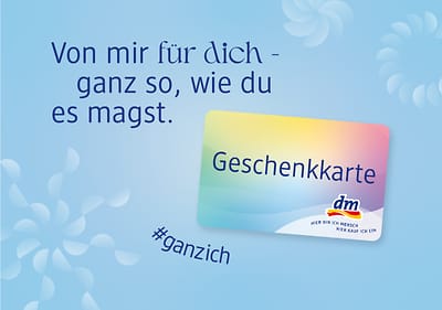 Ein blauer Hintergrund mit dem Text „Von mir für dich - ganz so, wie du es magst“. Eine dm-Geschenkkarte mit Farbverlauf und der Aufschrift „Geschenkkarte“. Darunter der Hashtag „#ganzich“