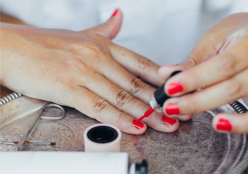 Nagellack auftragen auf Fingernägel mit rotem Nagellack
