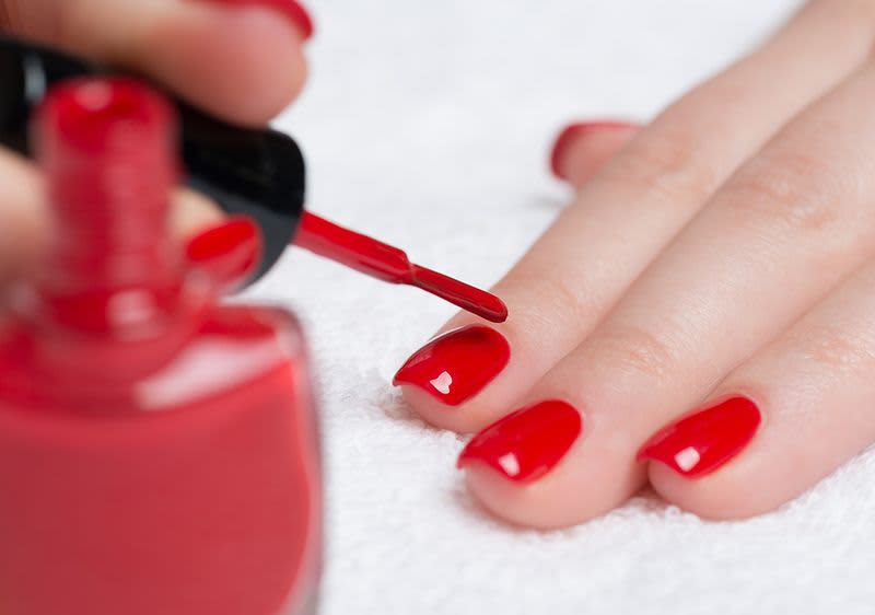 Nagellack auftragen auf roten Nägeln