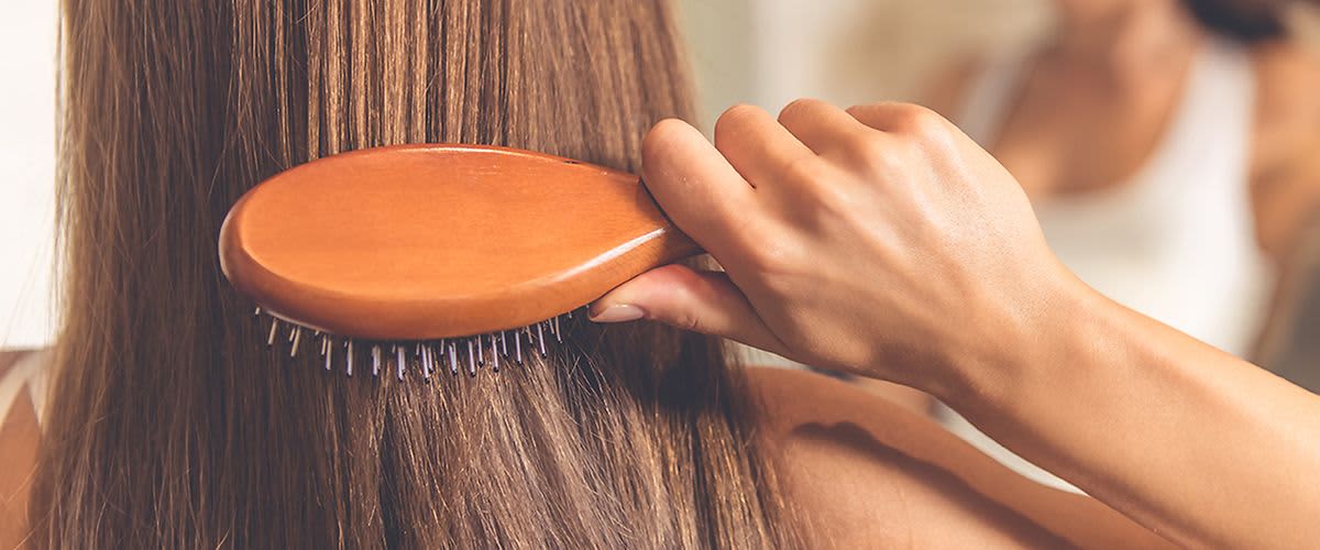 Frau bürstet ihre Haare