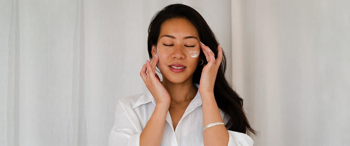 Frau mit dunkleren Haaren und Creme im Gesicht