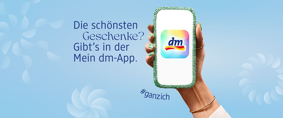 Eine Hand hält ein Smartphone mit dem dm-Logo und #ganzich Text
