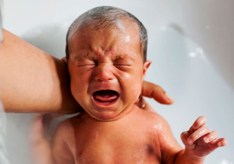 Baby wird gebadet und weint