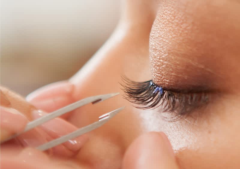Frau lässt sich Kunstwimpern machen