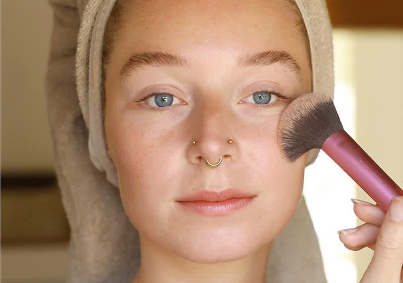 Frau trägt Puder auf