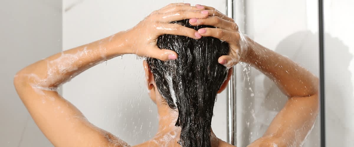 Frau wäscht sich die Haare