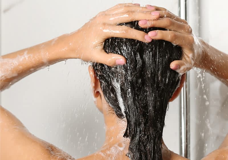 Frau wäscht sich die Haare