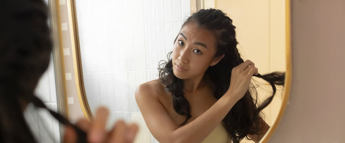 Frau die sich die Haare flechtet