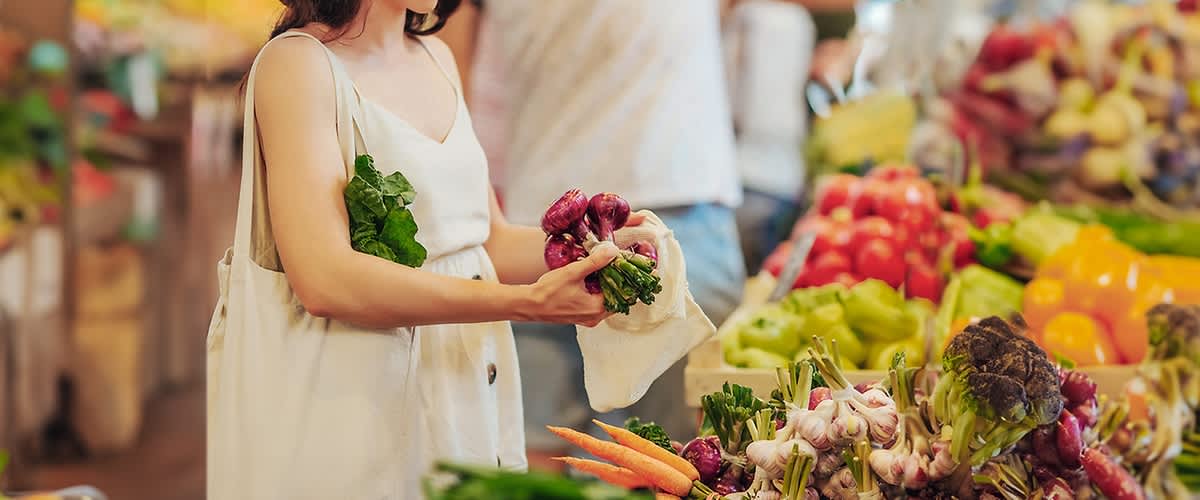 Frau beim Gemüse einkaufen