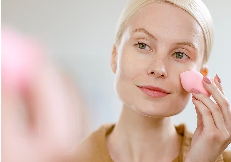 Frau trägt Foundation auf