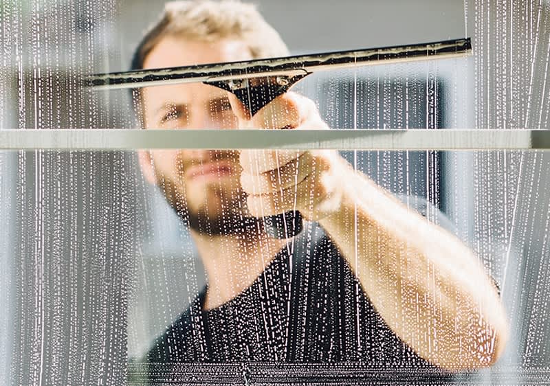 Person beim Fensterputzen