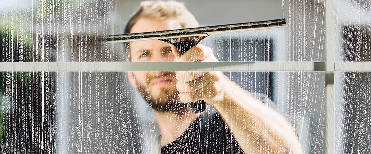 Person beim Fensterputzen