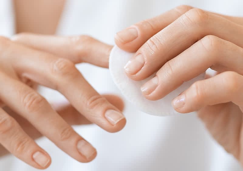 Frau reinigt Ihre Nägel