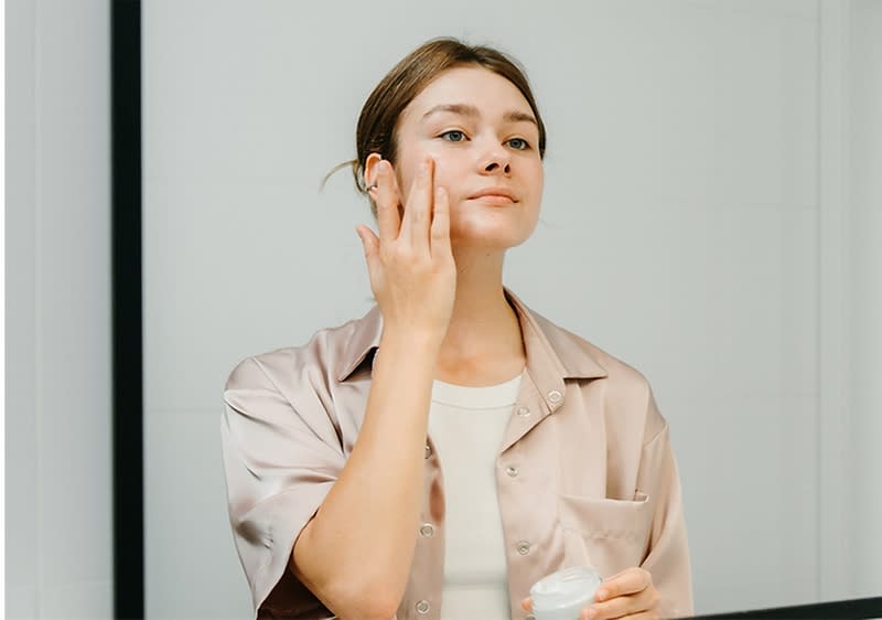 Junge Frau mit Haarturban bei der Gesichtspflege