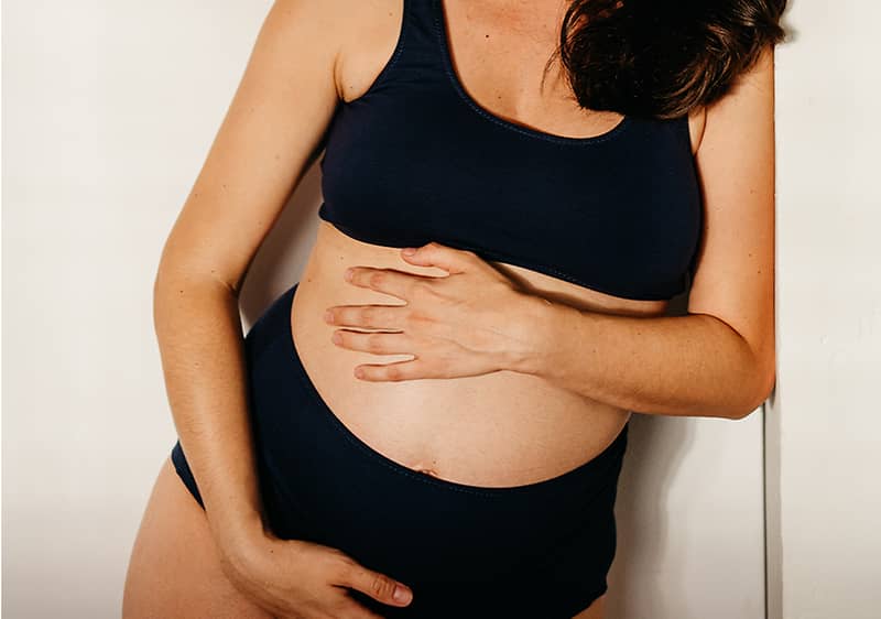 Schwangere Frau hält ihren Bauch
