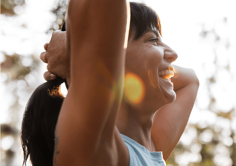Frau hält ihre Haare und lächelt