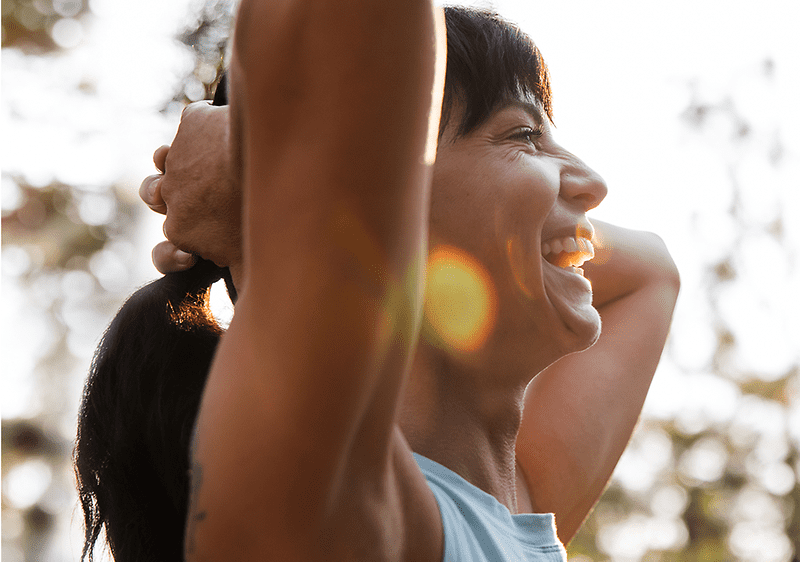 Frau hält ihre Haare und lächelt