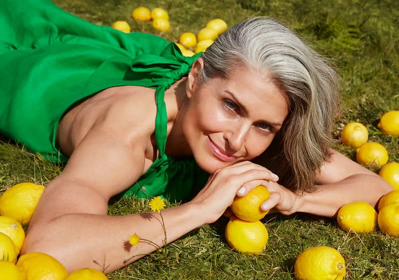 Frau liegt in Wiese mit Zitronen
