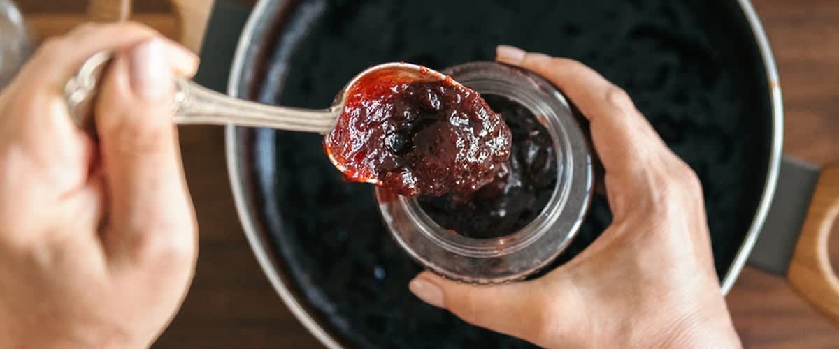 Marmelade wird in einen Topf gegeben