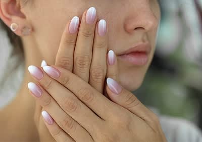 Fingernägel mit rosa-weißem Ombre-Design und Ohrstecker
