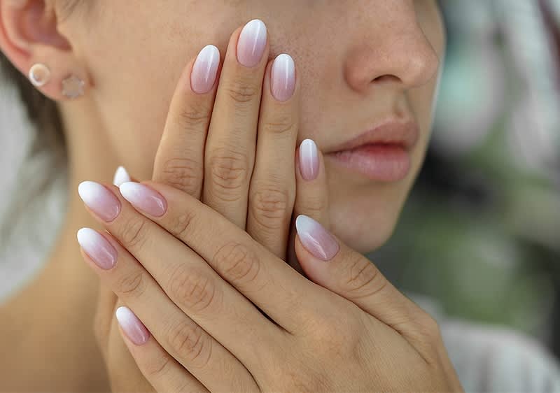 Fingernägel mit rosa-weißem Ombre-Design und Ohrstecker