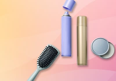 Eine lila Sprühflasche, eine goldene Flasche und eine schwarze Haarbürste auf einem rosa-gelben Hintergrund