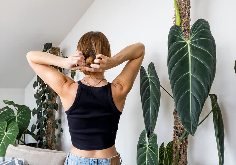 Frau drückt Dutt durch Öffnung