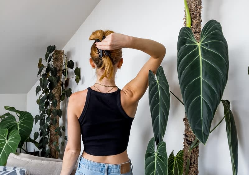 Frau fixiert den Dutt mit einer Haarklammer