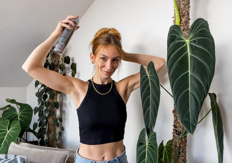 Frau trägt Haarspray auf