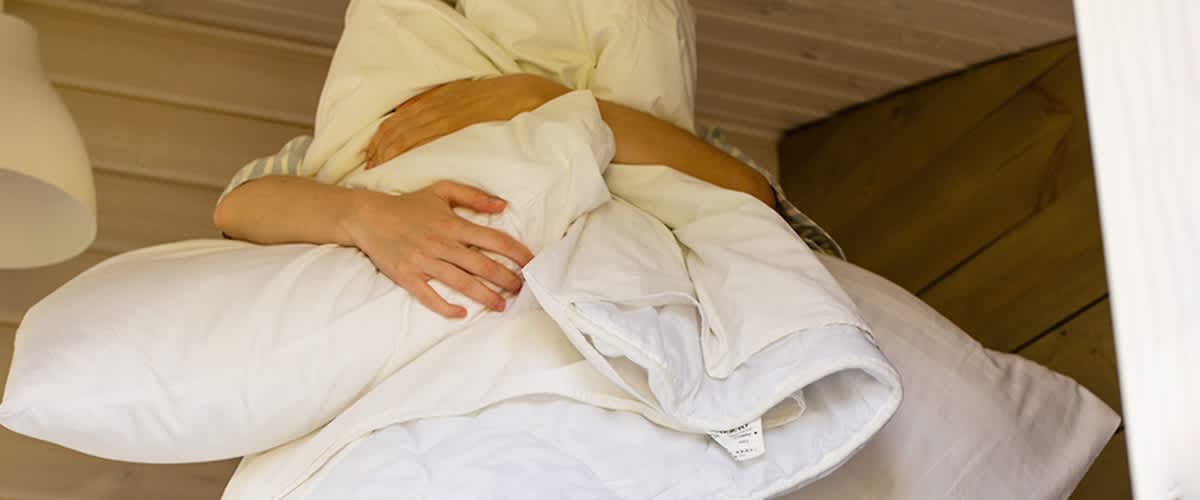 Person mit Daunendecke zugedeckt