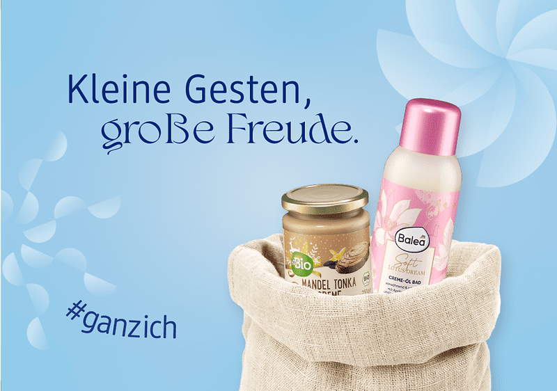 Ein beiger Nikolaussack enthält ein Glas Bio-Mandel-Tonka-Creme und eine Balea Creme-Öl-Dusche mit rosa Deckel, daneben der Text „Kleine Gesten, große Freude“ und der Hashtag „#ganzich“ auf blauem Hintergrund