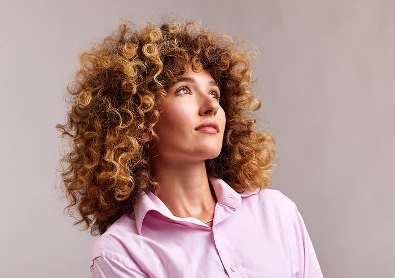 Frau mit haselnussbraunen lockigen Haaren