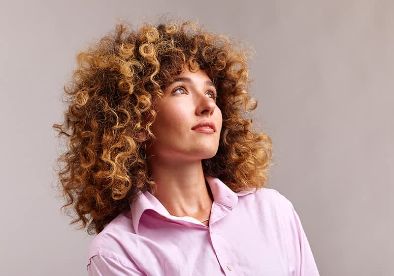 Frau mit haselnussbraunen lockigen Haaren