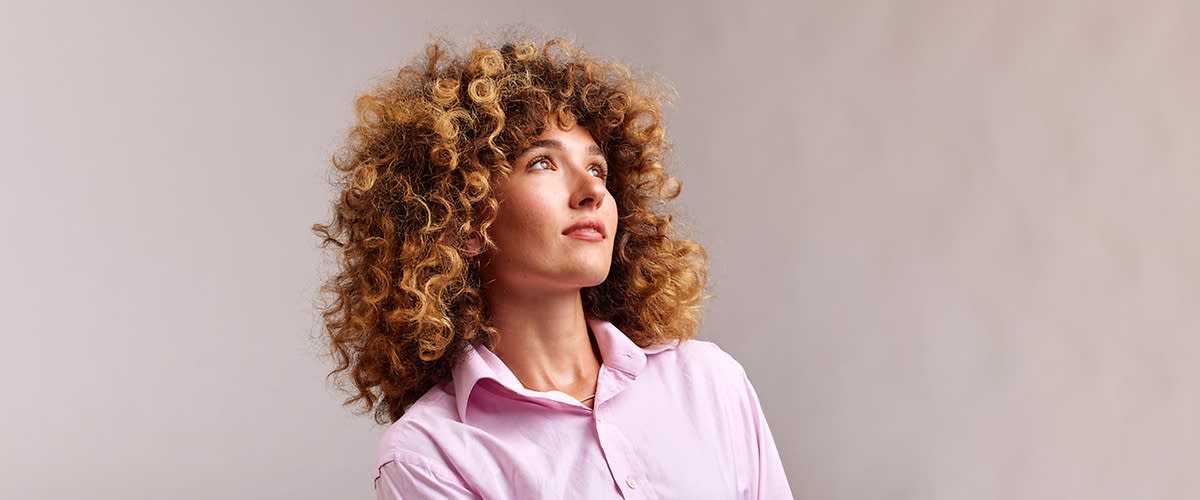 Frau mit haselnussbraunen lockigen Haaren