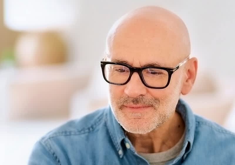 Mann mit Glatze und Brille in Freizeitkleidung
