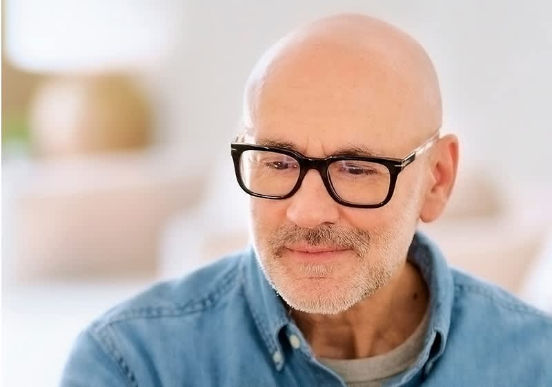 Mann mit Glatze und Brille in Freizeitkleidung